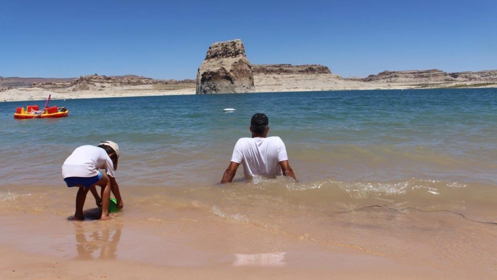 While the son enjoy the water and the sand, the father take the time to relax inside Lake Powell, at Glenn Canyon National Recreational Area